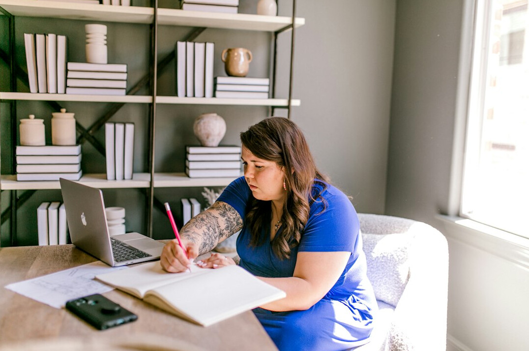 author writing at desk with notebook